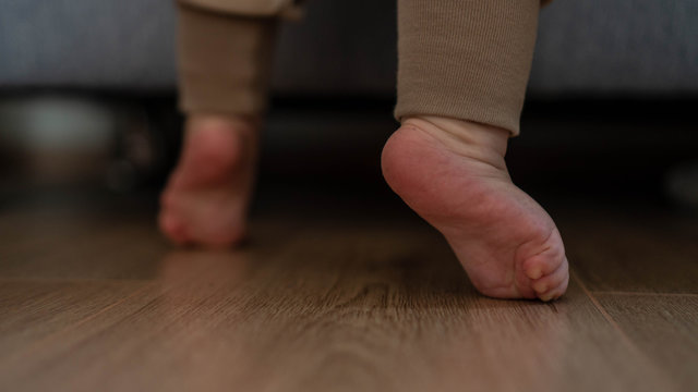 children's feet near the sofa. baby's first steps
