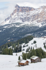 Fototapeta premium Pralongià, Italy - August 25, 2018: Alpine landscape with snowy meadows and huts