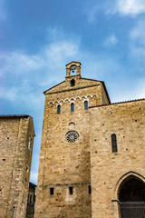 Fototapeta premium Side facade of the Cathedral Basilica of Santa Maria Annunziata, with the rose window, in Piazza Innocenzo III. Stone buildings from the Middle Ages. Anagni, Frosinone, Italy.