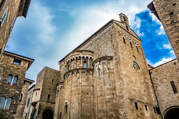 Fototapeta premium Side facade of the Cathedral Basilica of Santa Maria Annunziata, with the rose window and the 3 apses, in Piazza Innocenzo III. Stone buildings from the Middle Ages. Anagni, Frosinone, Italy.