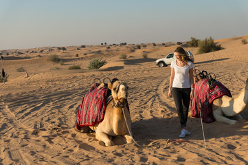 Travel girl with camel in Dubai desert 