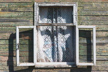 Old wall of wooden house with open window