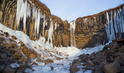 Ice Stalactites at Svartifoss waterfall in winter time during a sunny day