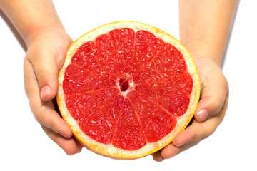 Hands child's holding a red grapefruit on white isolated background. healthy food concept. Hands kid holding grapefruit.