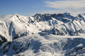 Fototapeta na wymiar Winter landscape with hills covered with snow at Pirin Mountain, view from Todorka peak, Bulgaria