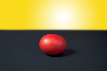 Red Easter egg on black and yellow background. Decoration for easter.