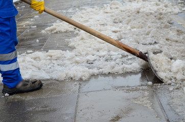 attendant shoveling snow on sidewalk