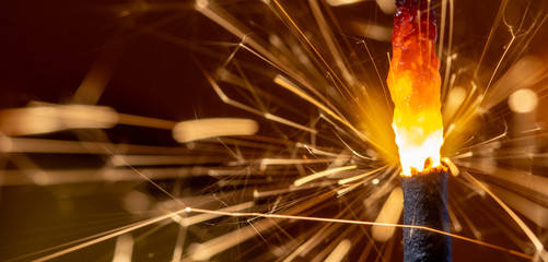 Flaming sparkler on red background close up macro