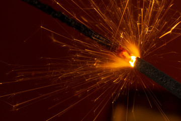 Flaming sparkler on red background close up macro