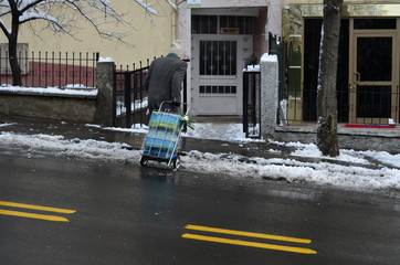 a old man carrying a market car