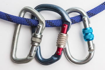 old used metal carabines in scratches on a rope for mountaineering on white background. Climbing concept