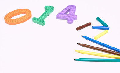 colorful markers on white background with colored numbers. children's markers for drawing. copy space. the view from the top. the concept of the school.