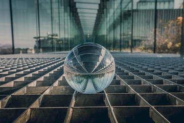 Close up of a glass sphere. Metal floor and glass tunnel.