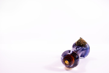 Glass pipe with marijuana bud on white background with copy space