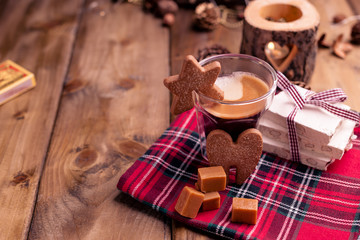 Fresh aromatic coffee and Italian Christmas sweets. Nougat with almonds, karemelnye sweets, ginger cookies and hot drink. Candles and holiday decorations. Free space for text.