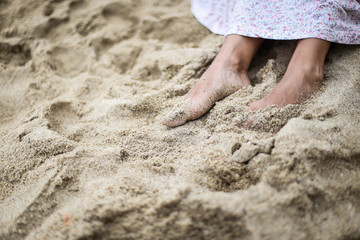The feet of a young woman in the sand