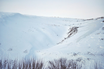 Winter landscape with trees on the slopes of the ravine. Evening serene picturesque view of Ukraine.