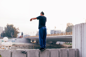 Parkour guy in action while exercising parkour at urban place.