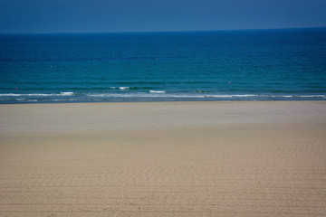 Blurred a background of golden sand and turquoise sea waves. Blurred basic background for design