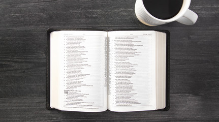 A Single Black Bible Laid Out on a Black Wooden Table