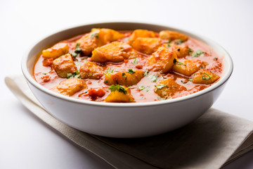 Indian food - Aloo curry masala. Potato cooked with spices and herbs in a tomato curry. served in a bowl over moody background. selective focus
