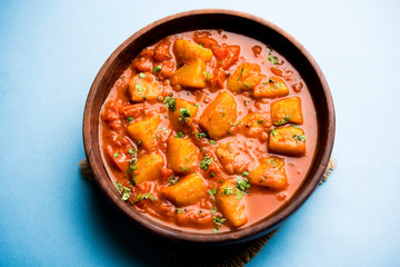 Indian food - Aloo curry masala. Potato cooked with spices and herbs in a tomato curry. served in a bowl over moody background. selective focus - obrazy, fototapety, plakaty