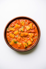 Indian food - Aloo curry masala. Potato cooked with spices and herbs in a tomato curry. served in a bowl over moody background. selective focus