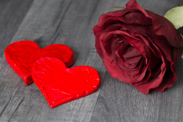 Two red heart shape and red rose flower on wooden background. Valentine's Day
