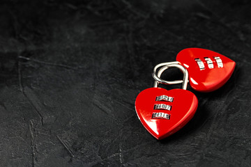 two red heart shape code padlocks with copy space on black textured background. Valentine's Day