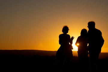 Fototapeta premium silhouette of a family on the beach at sunset