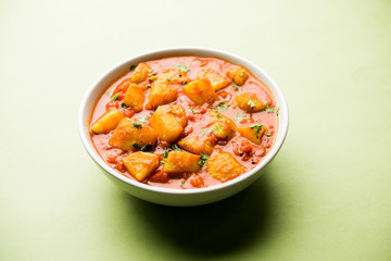 Indian Aloo Mutter curry - Potato and Peas immersed in an Onion Tomato Gravy and garnished with coriander leaves. Served in a Karahi/kadhai or pan or bowl. selective focus