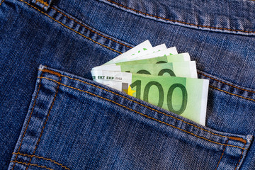 Euro bills in jeans pocket background. Euro banknotes in jeans back pocket. Concept of rich people, saving or spending money. Euro bills falling out. Easy to steal the money. Irresponsible action.