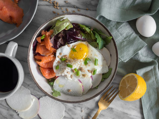 Smoked salmon breakfast salad made with a spring mix, egg, fish, radish, and chives. 