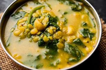Dal Palak or Lentil spinach curry - popular Indian main course healthy recipe. served in a karahi/pan or bowl. selective focus