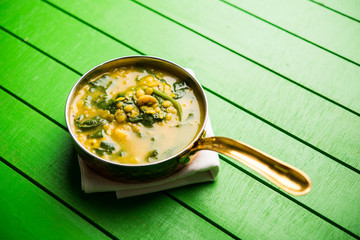 Dal Palak or Lentil spinach curry - popular Indian main course healthy recipe. served in a karahi/pan or bowl. selective focus