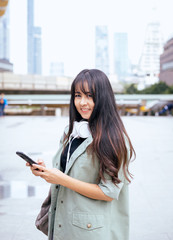 Fototapeta premium Portrait beautiful asian woman using mobilephone and walking in the city,Female confidence happy and smiling,Lifestyle concept