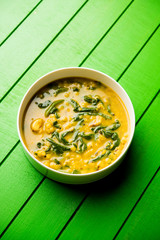 Dal Palak or Lentil spinach curry - popular Indian main course healthy recipe. served in a karahi/pan or bowl. selective focus