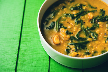 Dal Palak or Lentil spinach curry - popular Indian main course healthy recipe. served in a karahi/pan or bowl. selective focus