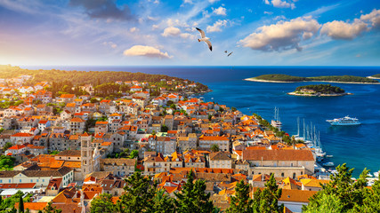 Hvar town with seagull's flying over city, famous luxury travel destination in Croatia. Boats on Hvar island, one of the many Islands near Dubrovnik and Korcula on the Dalmatian Coast of Croatia.