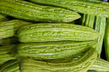 Close up of fresh bitter melon, selective focus.Heap of chinese bitter melon fruit (Momordica charantia) for retail sale in Thailand fresh food market.