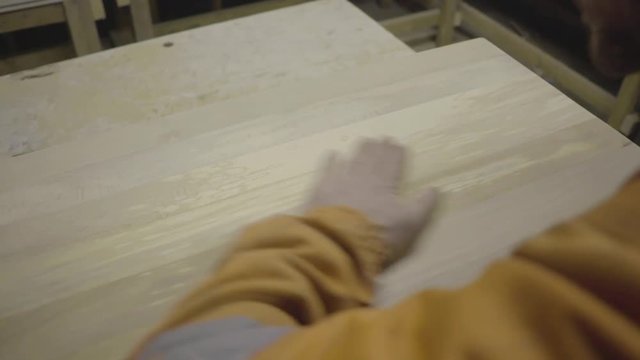 blows dust and rubs hand over finished wood above self employed carpenter wood
