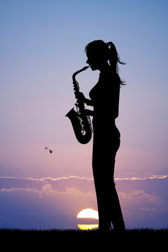 woman plays the sax at sunset