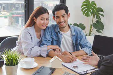 new house / home moving and relocation concept. Happy asian couple signing contract to buy apartment.