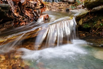A long exposure closeup of a small waterfall with a twirling pattern in the forest in Belvidere, Tennessee.