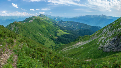 Naklejka premium View over the Green Valley, surrounded by high mountains on a clear summer day