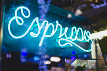 The glowing blue light of the espresso sign in the shop window. 