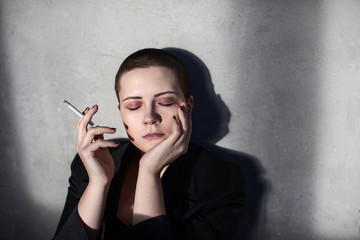 Girl with short haircut smokes cigarette