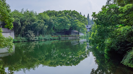Traditional Chinese buildings by water among trees, near West Lake, Hangzhou, China
