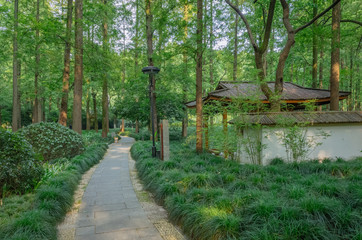 Path next to traditional Chinese architecture in woods near West Lake in Hangzhou, China