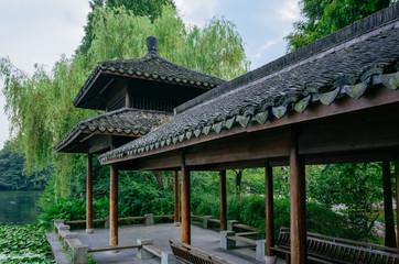 Traditional Chinese pavilion by water covered with lotus leaves, at West Lake, Hangzhou, China